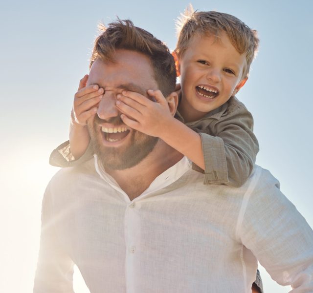 Dad, child and piggy back with covering eyes for game, playing and funny time in sunshine with love. Sun, sky and family with bonding, father and kid while laughing, comic and happy together outdoor.